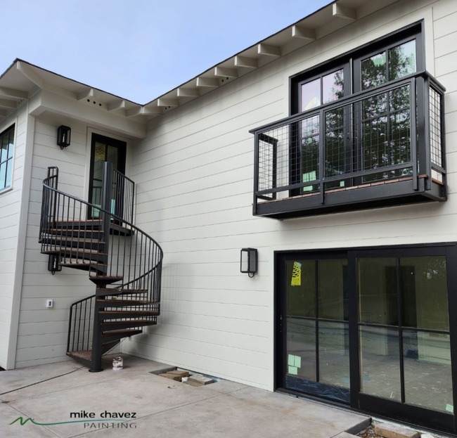 An Elegant Home Featuring a Spiral Staircase and Balcony.