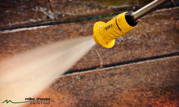 A Yellow Hose Pressure Washing a Brick Wall.