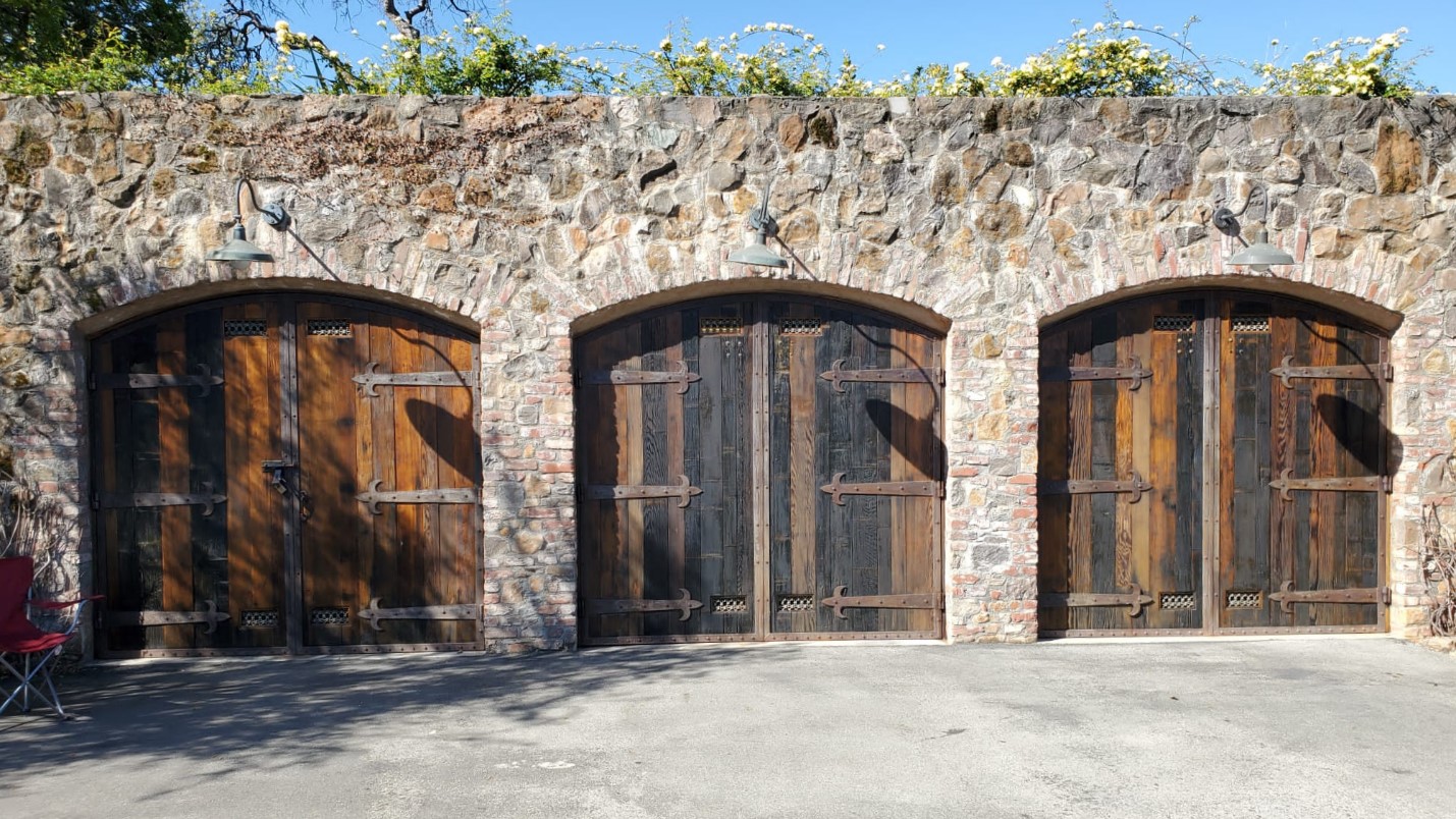 A Stone-crafted Building With Three Wooden Double Doors Inlaid Across the Face.