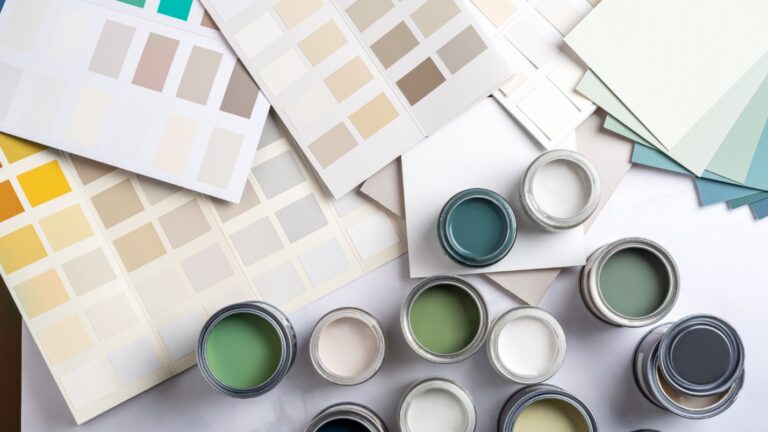 A range of paint colors displayed on paper and various small pots of paint