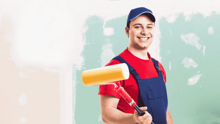 A professional painter in overalls holds a paint roller