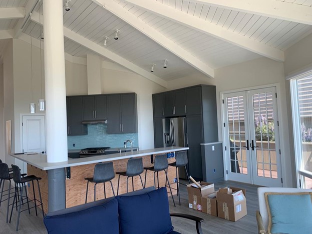 A modern open-concept kitchen and living room that has been freshly painted.