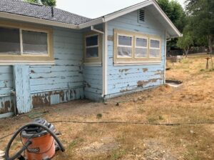 A home’s light-blue exterior that is peeling paint.