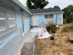 A home’s light-blue exterior that is peeling paint. 