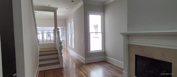 A hallway painted with a soft neutral color with white baseboards and molding.