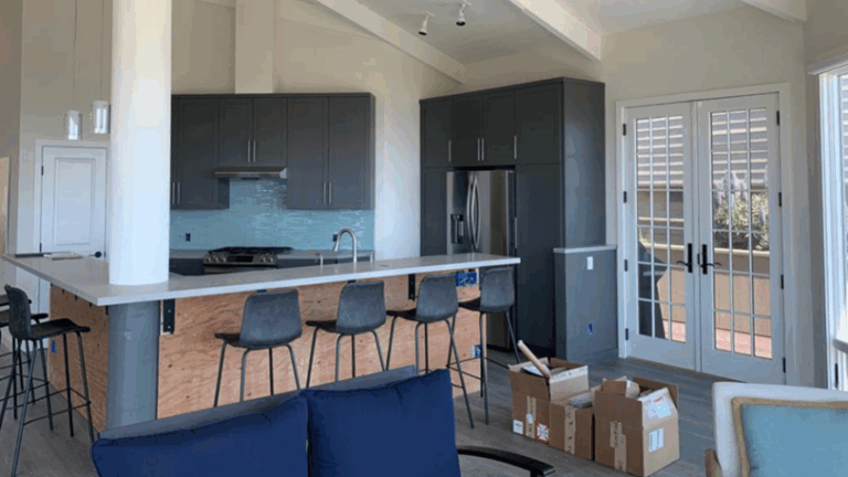 A modern kitchen with cabinets that have just been painted a dark color