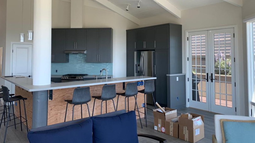 A modern kitchen with cabinets that have just been painted a dark color