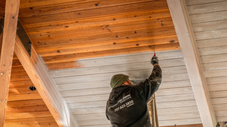 An wooden ceiling in a commercial building that is in the process of being stained.