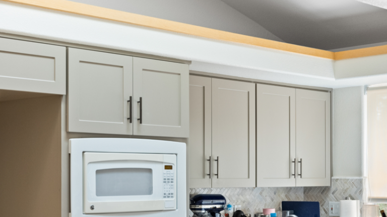 Kitchen cabinets that have been freshly painted in a light beige color.
